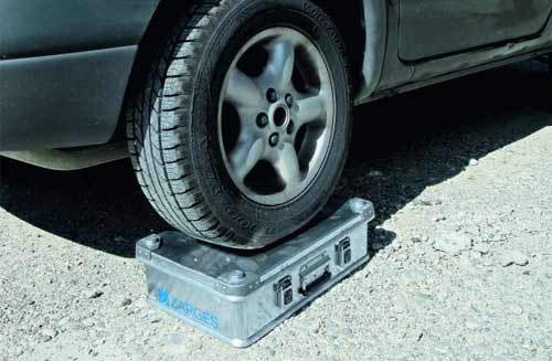 A car wheel resting on top of an aluminium case