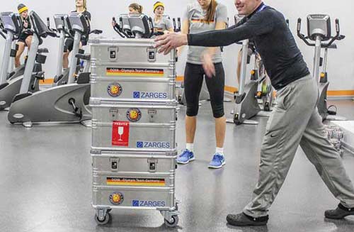 A kit manager in a changing room pushing an aluminium kit skip