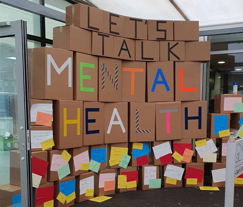 support-for-mental-health-project Wall of cardboard boxes with mental health suggestions attached