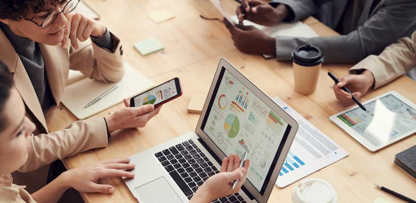 Business-people analysing sales figures on a laptop