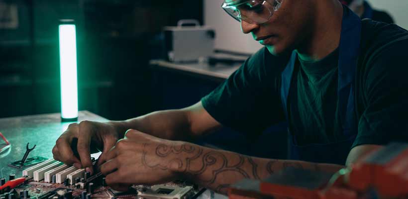A person working on a electronic assembly