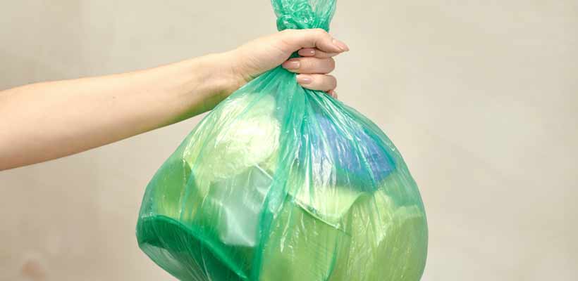What is sustainable packaging? A person holding a plastic bag full of waste packaging