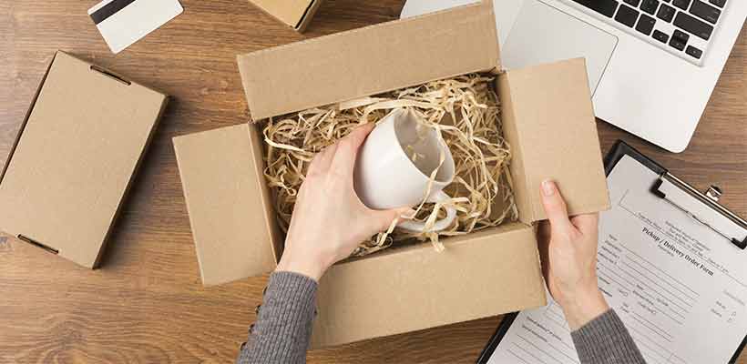 Top view of a woman preparing a box with packaging innards.