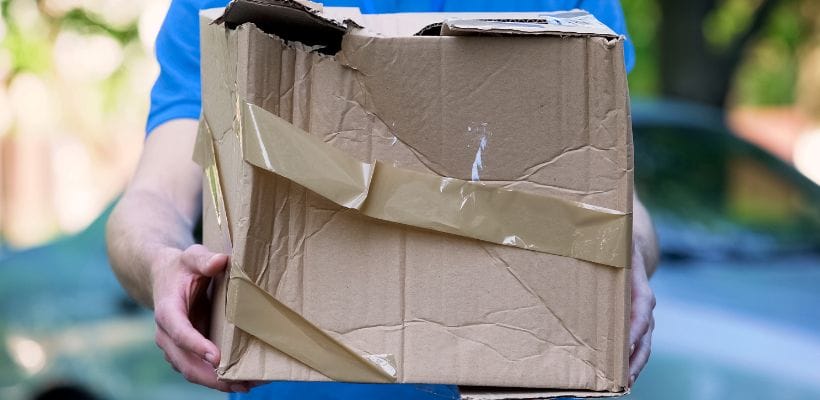 Someone holding a damaged parcel.