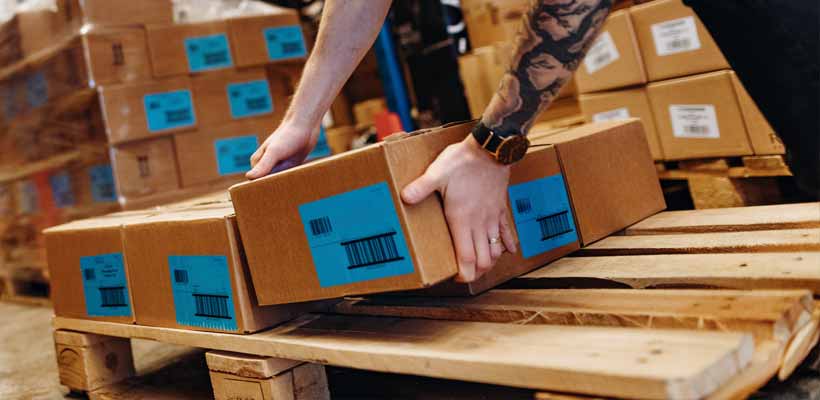 Heat treated pallets A person placing boxes on a heat treated pallet