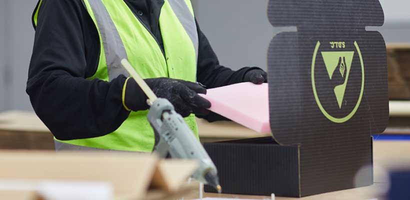 def-stan-packaging-manufacturer A person adding foam to specialist anti-static packaging.