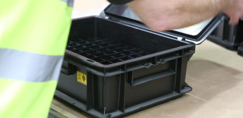 A person placing dividers in an SSI Schaefer tote box