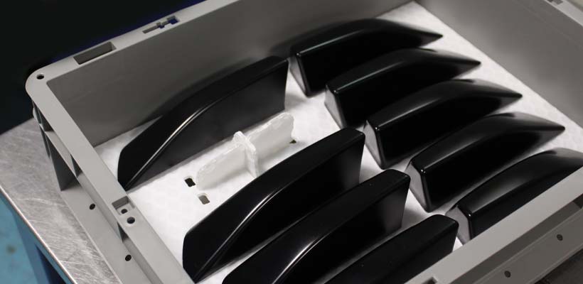 Automotive parts in a grey plastic container