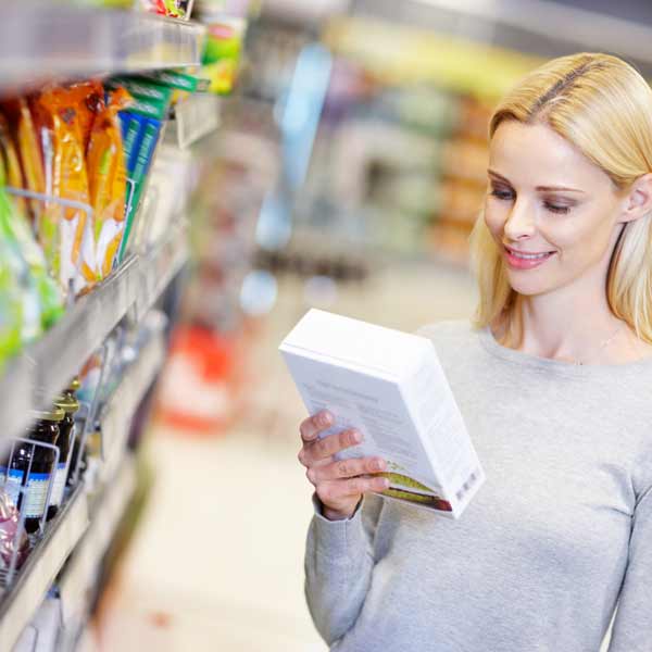 Retail packaging A woman looking at retail packaging in a supermarket