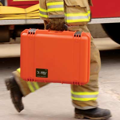 A person in overalls carrying a protective case