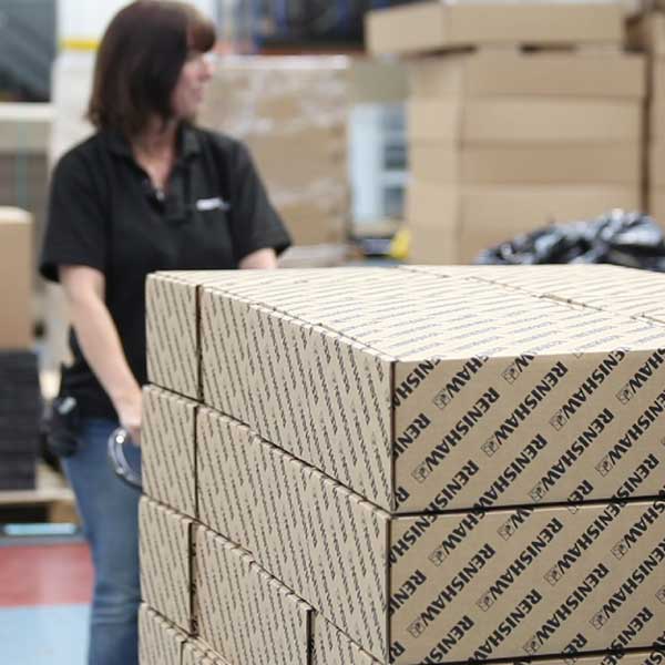 UK packaging companies A person moving a stack of boxes at a UK packaging company