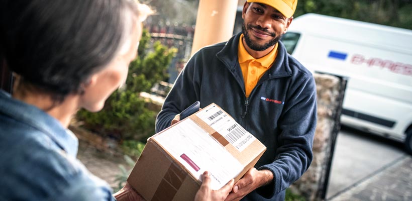 Subscription box packaging A courier handing over subscription box packaging to a customer.