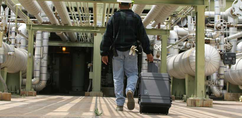 A person pulling a Peli Protector case through a production facility.