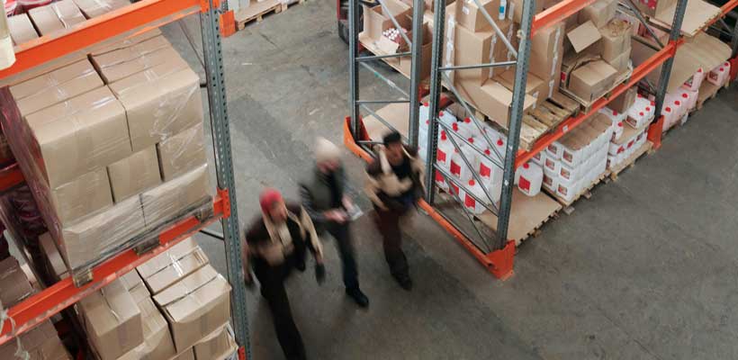 Three people undertaking training in a warehouse.