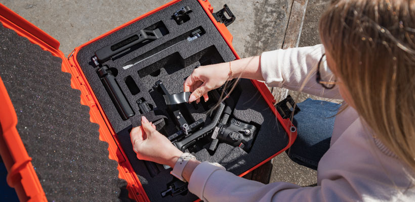 Case customisation A person removing equipmnet from a nanuk case with custom foam inserts.