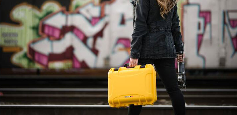 Protective carry cases A person carrying a yellow Nanuk case